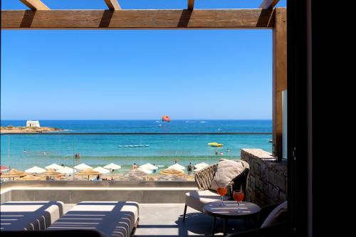 a view of the beach from a restaurant with tables and chairs at High Beach Resort in Malia
