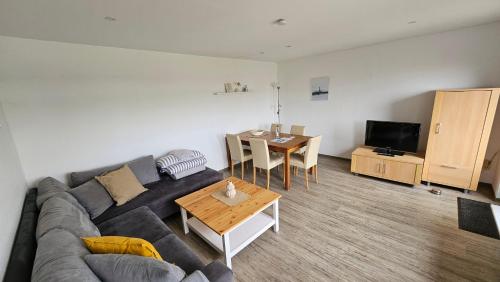 a living room with a couch and a table at Haus Windjammer in Neuharlingersiel