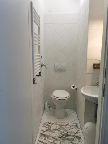 a white bathroom with a toilet and a sink at Mezzomonte View in Impruneta