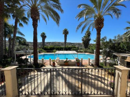 a villa with a pool and palm trees at ALTA lux homeholiday stone in Modica