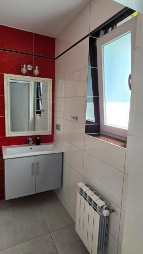 a bathroom with a sink and a window at Jaworina- Apartamenty, Domki i Pokoje in Solina