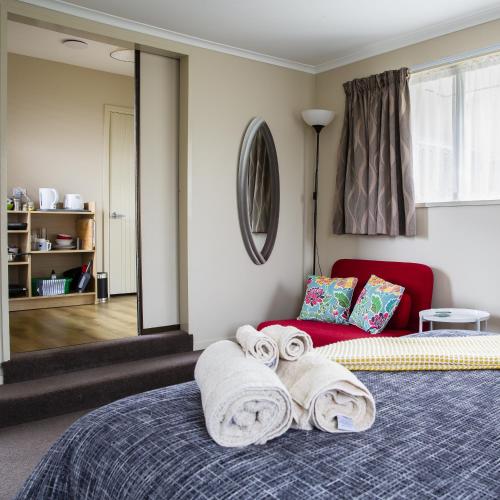 a bedroom with two rolled towels on a bed at Chic Private Studio 5 mins from Airport and shops in Christchurch