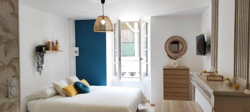 une chambre avec un lit, une fenêtre et un miroir dans l'établissement 3- L'Elégant - Sarlat - Centre ville, à Sarlat-la-Canéda