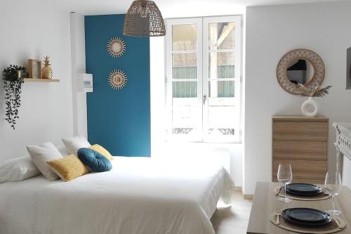 - une chambre avec un lit blanc et un mur bleu dans l'établissement 3- L'Elégant - Sarlat - Centre ville, à Sarlat-la-Canéda