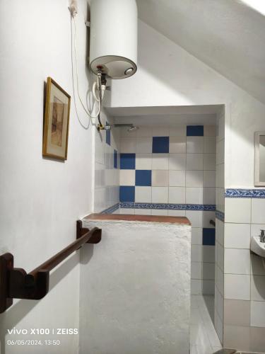 a bathroom with blue and white tiles on the wall at Isai Ambalam guest house in Puducherry