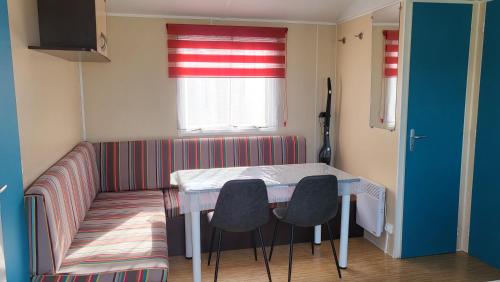 une petite chambre avec une table, des chaises et une fenêtre dans l'établissement Le Phare d'Opale II, N18, à Le Portel