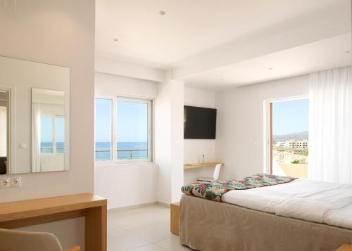 a bedroom with a bed and a view of the ocean at High Beach Resort in Malia