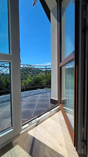 an open glass door with a tennis court outside at Jaworina- Apartamenty, Domki i Pokoje in Solina