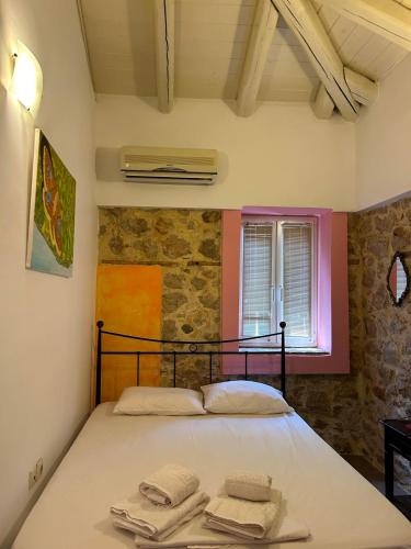 a bedroom with a bed with towels on it at Sofia Apartments in Paralía Iríon