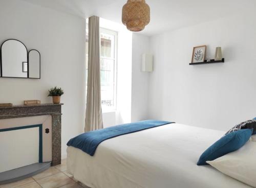 une chambre blanche avec un lit et une cheminée dans l'établissement 4- Le Sauvage - Sarlat - Centre Ville, à Sarlat-la-Canéda