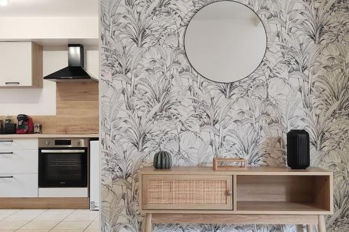 une cuisine avec un miroir sur un mur avec une table dans l'établissement 4- Le Sauvage - Sarlat - Centre Ville, à Sarlat-la-Canéda