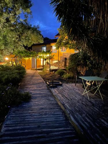 a wooden pathway leading to a house at night at Moinho do Granjão - Water Mill in Mesão Frio