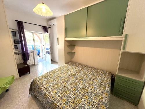a bedroom with a bed and green cabinets at Appartamenti Miramare in Collina in Ischia