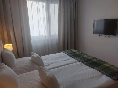 a hotel room with a bed and a flat screen tv at New Selina Byt in Levoča