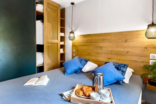 a room with a bed with a tray of food on it at Au Paradis des Campeurs in Les Issambres
