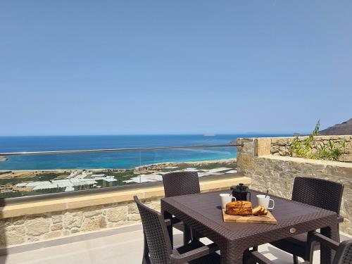 a table with a plate of food on a balcony at Studios Rosmari in Áyioi Pándes