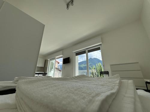 a white bedroom with a large bed and a window at Luxury Apartment SOLE in Moltrasio