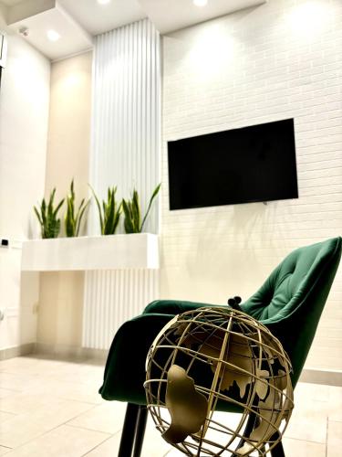 a living room with a green chair and a television at B&B Casa Dolce Casa in Nardò