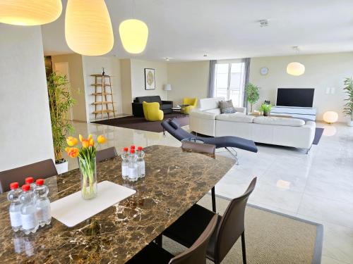a living room with a table and a couch at Montreux Four Bedroom Penthouse by Swiss Hotel Apartments in Montreux