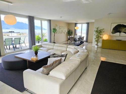 a living room with a white couch and a table at Montreux Four Bedroom Penthouse by Swiss Hotel Apartments in Montreux