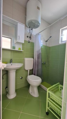 a green bathroom with a toilet and a sink at Apartments Mare in Ulcinj