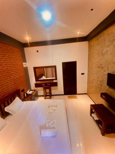 a large bedroom with a bed and a piano at Coffee House Dambulla in Dambulla