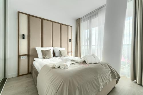 a bedroom with a large bed with two towels on it at Your Holidays Waves in Międzyzdroje