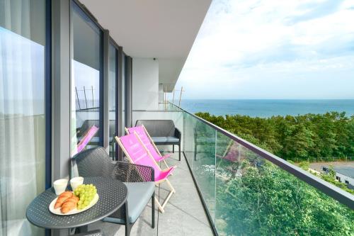 a balcony with a table and chairs and the ocean at Your Holidays Waves in Międzyzdroje