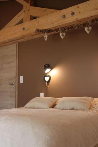 - une chambre avec un lit blanc et un plafond en bois dans l'établissement Gîte du Pré Chappa, Parc Naturel des Hautes Vosges, à Saint-Maurice-sur-Moselle