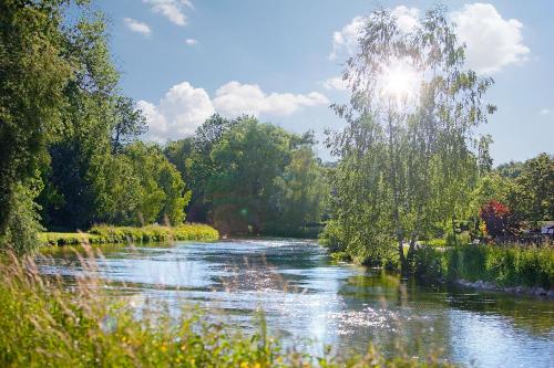 a river with the sun reflecting on the water at Hotel Schiller in Olching