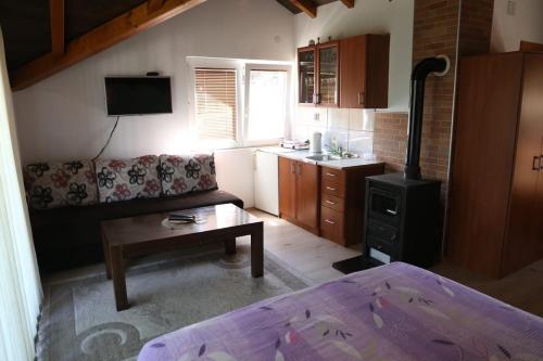 a small living room with a bed and a table at Apartment Prole in Šipovo