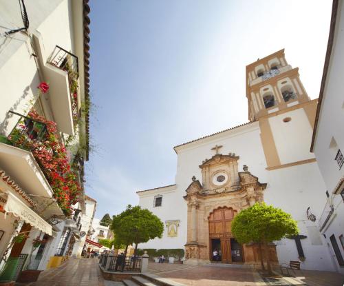 a church with a clock tower on a street at Aqua Apartments Bellamar, Marbella in Marbella