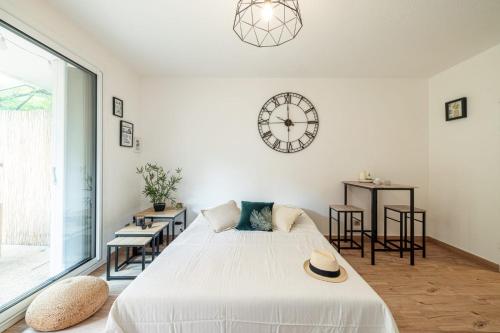 une chambre avec un lit et une horloge au mur dans l'établissement Relax Garden, Swimming pool in French Riviera, à Cagnes-sur-Mer