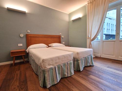a bedroom with two beds and a large window at B&B Residenza Cavour in Como