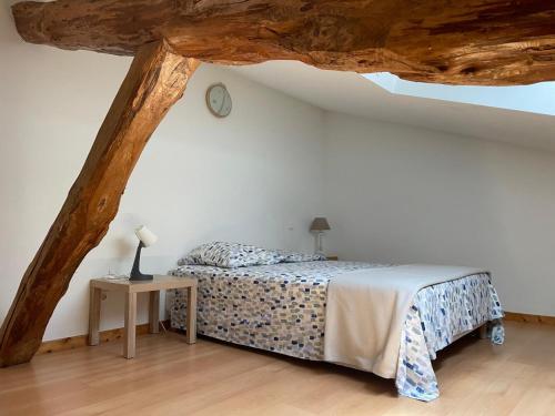 - une chambre avec un lit et une table avec une horloge dans l'établissement Ferme rénovée 6 chambres, vue sur lac et piscine, à Castet-Arrouy