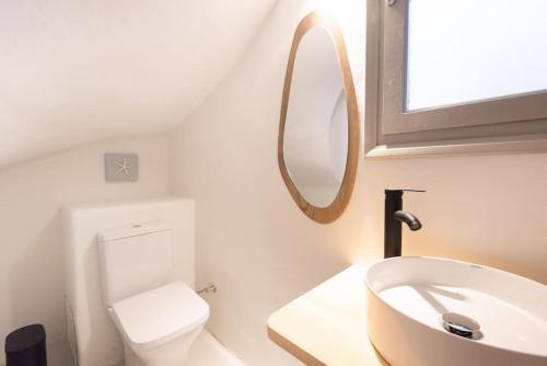 a bathroom with a sink and a toilet and a mirror at Swell S10 maisonette with private Jacuzzi in Naousa in Naousa
