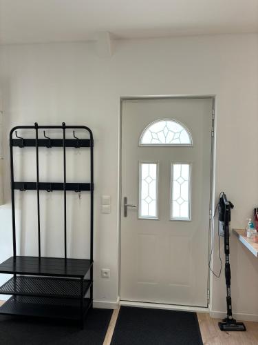 Cette chambre dispose d'une porte blanche et d'une fenêtre. dans l'établissement Maison des Larris - proche Aéroport - navette Gare, à Beauvais