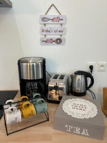 - un comptoir avec une cafetière et une boîte dans l'établissement Maison des Larris - proche Aéroport - navette Gare, à Beauvais