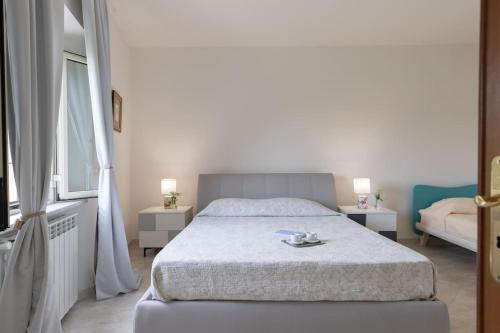 a bedroom with a bed and two tables and a window at Casa Il Fico in Usigliano