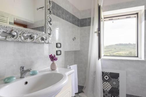 a bathroom with a sink and a mirror and a window at Casa Il Fico in Usigliano