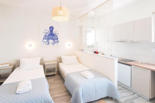 two beds in a white room with a kitchen at Swell S11 new studio in Naousa in Naousa