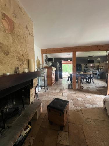 un salon avec une cheminée en pierre et une table dans l'établissement Villa au cœur de la Provence, à Évenos