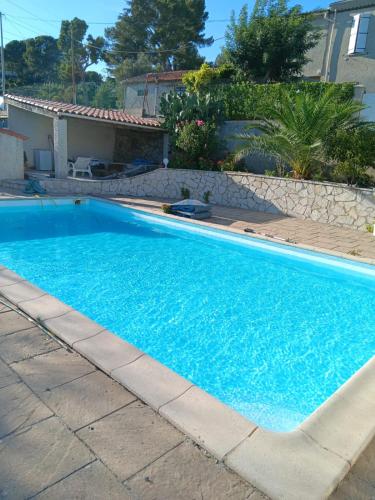 une grande piscine bleue devant une maison dans l'établissement Les Accatines, à Marseille