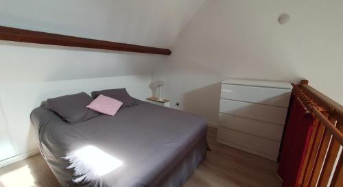 - une chambre avec un lit et un oreiller rose dans l'établissement Appartement Sainte Marie de Campan, à Sainte-Marie-de-Campan