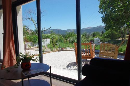 un salon avec une grande porte vitrée donnant sur un patio dans l'établissement Les Accatines, à Marseille