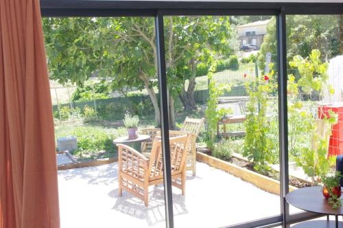 Elle offre une vue sur une terrasse avec une table et des chaises. dans l'établissement Les Accatines, à Marseille