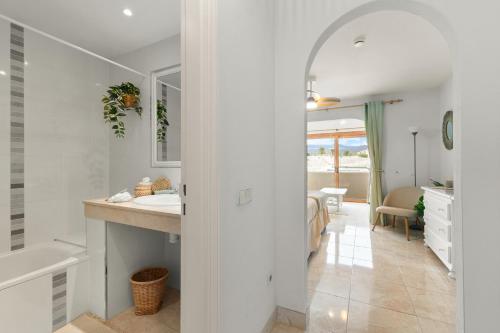 a white bathroom with a sink and a mirror at Beautiful 4 bedroom house with phenomenal golf and mountain views in San Miguel de Abona