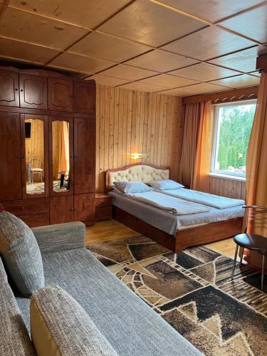 sypialnia z łóżkiem, kanapą i oknem w obiekcie Cunami w mieście Nida