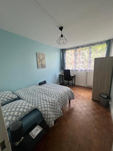 une chambre avec un lit, une chaise et une fenêtre dans l'établissement Appt T3, 65 m2 proche de Paris, à Méry-sur-Oise