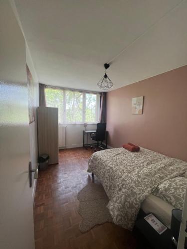une chambre avec un lit, un bureau et une fenêtre dans l'établissement Appt T3, 65 m2 proche de Paris, à Méry-sur-Oise